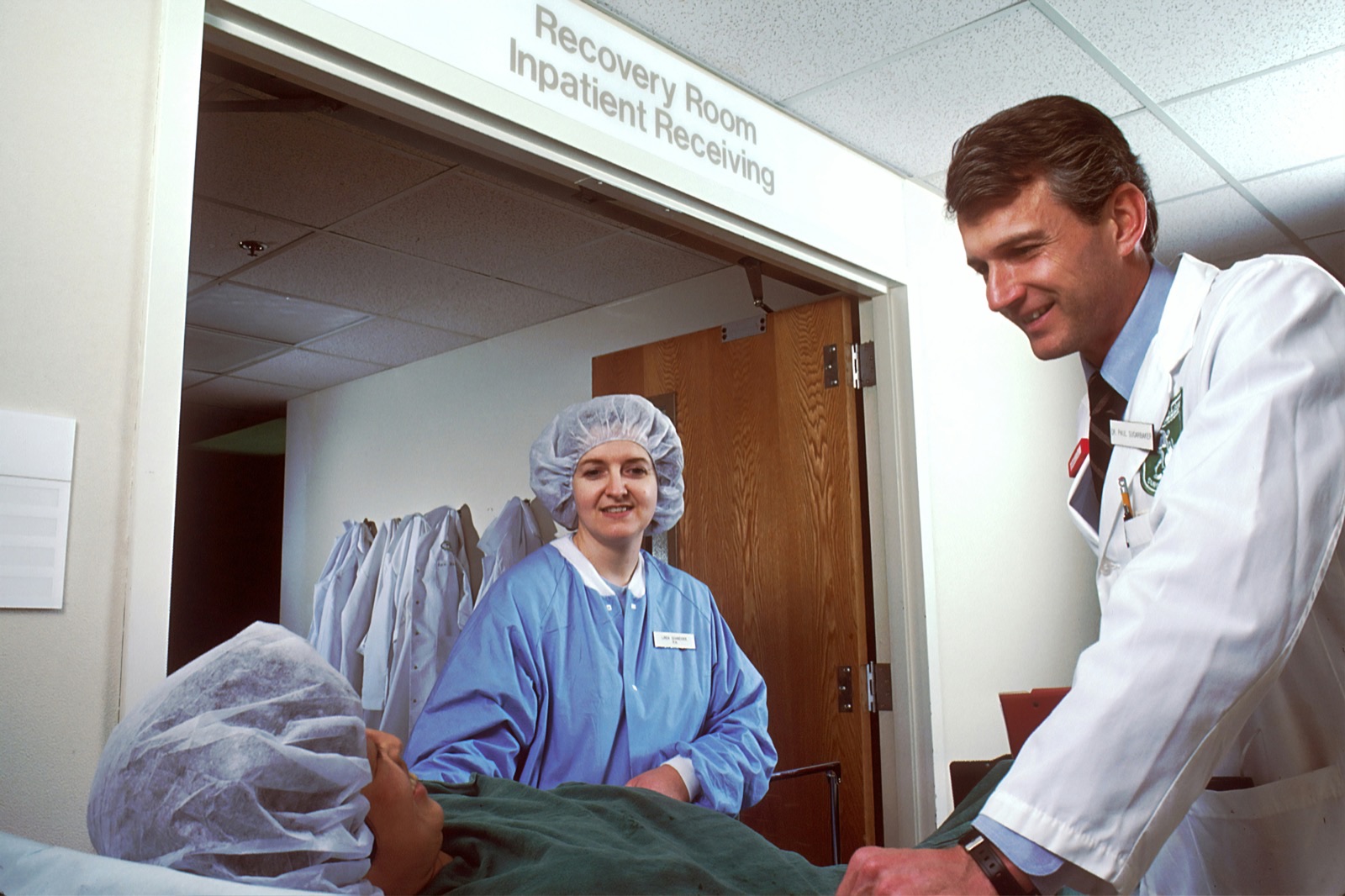 A healthcare professional reviews a tablet with a concerned expression, symbolizing the operational challenge of managing a potential surge in patient communications during a public health alert.