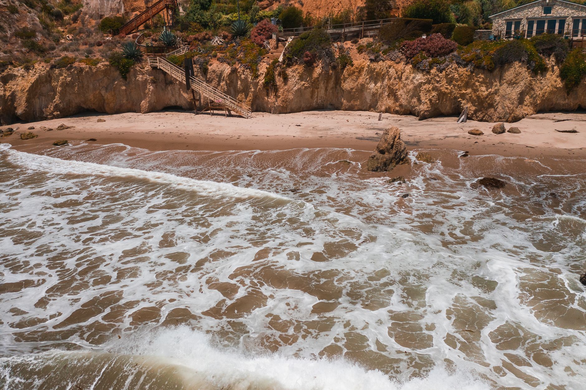 A breathtaking aerial shot of El Matador Beach in Malibu showcasing waves crashing on the shore.